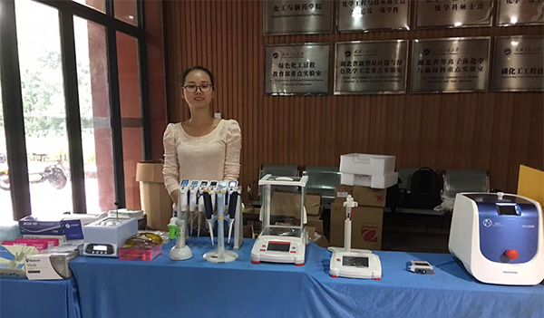 集思仪器销售人员在展会上向客户展示奥豪斯电子天平、梅洁移液器、细胞破碎仪等科学仪器设备